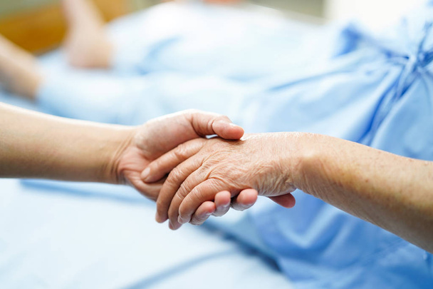 Tenir la main touchante Vieille dame asiatique âgée ou âgée patiente avec amour, soins, aide, encouragement et empathie à l'hôpital infirmier : concept médical solide et sain
 - Photo, image