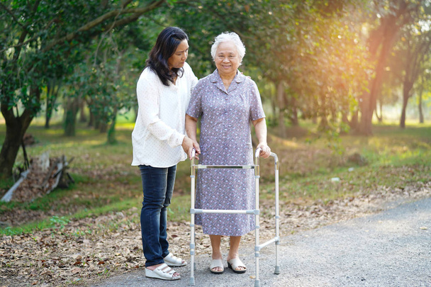 Azjatycki seniora lub starsza pani pacjentka chodzić z Walker w parku: zdrowe silnej koncepcji medycznej - Zdjęcie, obraz