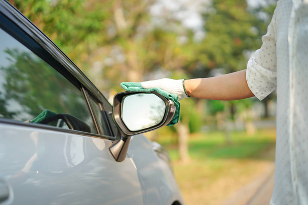Cleaning car with green color microfiber cloth outdoor in holiday.  - Photo, image
