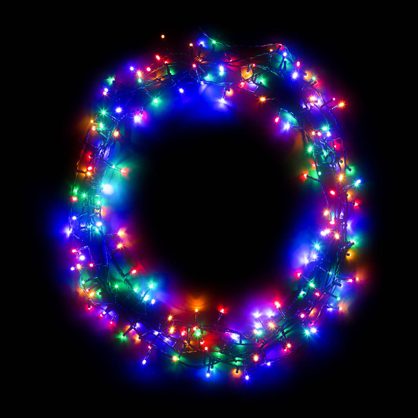 Arabic numeral "0" from a multi-colored electric garland on a black isolated background. New year numbers. A wreath of colored light bulbs. Congratulations frame concept - Photo, Image