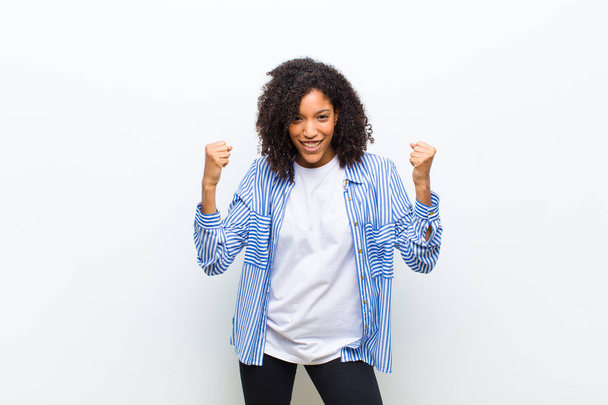 young cool african american woman feeling happy, surprised and proud, shouting and celebrating success with a big smile - Фото, изображение