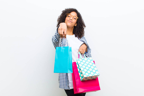 young pretty black woman with shopping bags against white wall - Photo, image