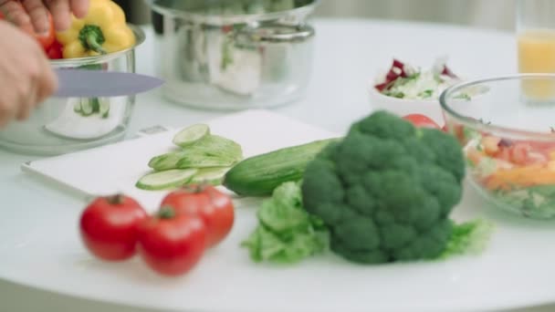 Closeup man hands chopping cucumbers on kitchen table in slow motion. - Materiał filmowy, wideo