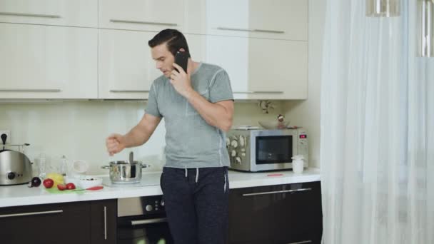 Un uomo arrabbiato che parla al telefono in cucina. Uomo aggressivo braccia oscillanti
 - Filmati, video