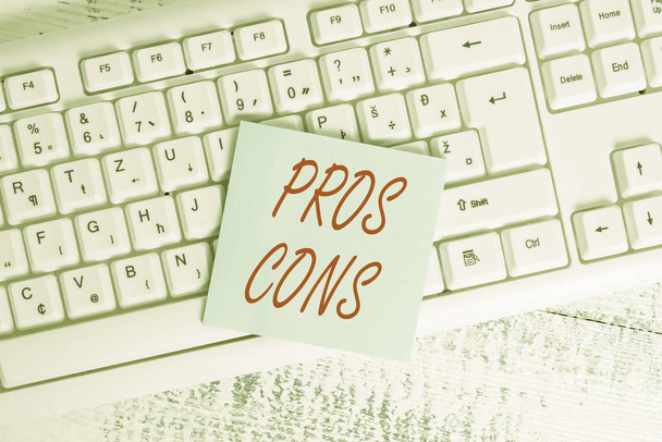 Conceptual hand writing showing Pros Cons. Business photo showcasing The favorable and unfavorable factors or reasons of demonstrating Keyboard office supplies rectangle shape paper reminder wood. - Photo, Image