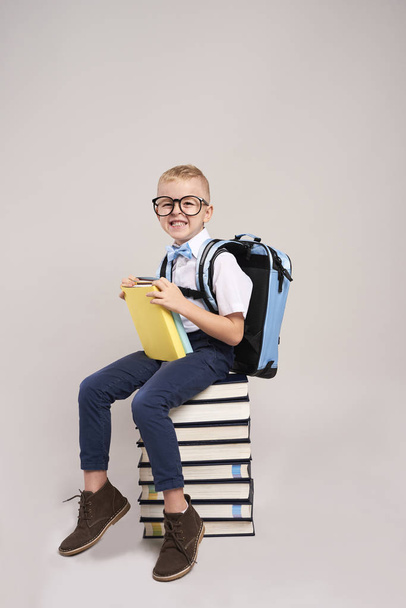 Happy child with backpack and stack of books - Valokuva, kuva