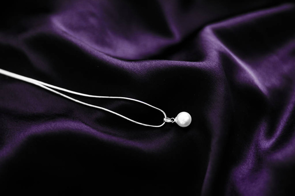 Luksusowe białe złoto perłowy naszyjnik na ciemnym fioletowym tle jedwabiu, - Zdjęcie, obraz