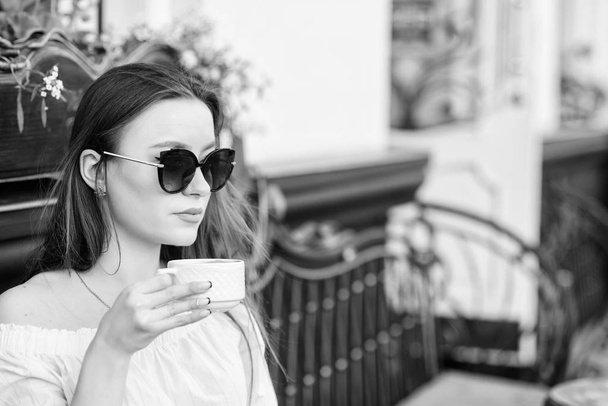 Girl relax in cafe cappuccino cup. Caffeine dose. Coffee for energetic successful day. Breakfast time in cafe. Girl enjoy morning coffee. Woman drink coffee outdoors. Peaceful inspiring moment - Photo, Image