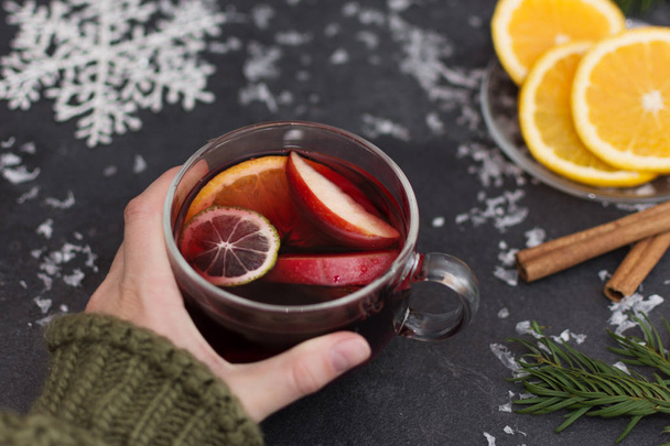 Woman holding a glass cup of hot Christmas mulled wine in hands, closeup. - Photo, Image