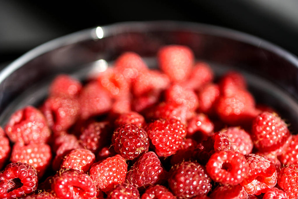 Red raspberry in a glass plate. Blur background - Photo, Image