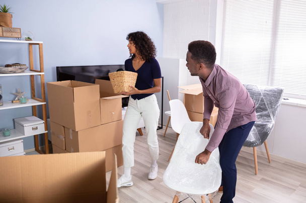 Couple Unpacking Boxes In Living Room In Their New Home - 写真・画像