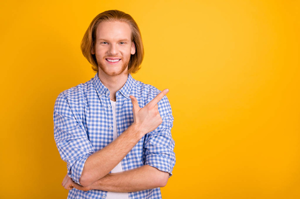 Photo of cheerful handsome confident bearded freelancer pointing at most profitable locations wearing white t-shirt smiling toothily isolated over yellow vibrant color background - Foto, Imagen