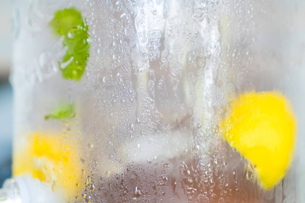Наповнена вода з лимоном і пасовищем в резервуарі для холодної води для детоксикації і здорового
. - Фото, зображення