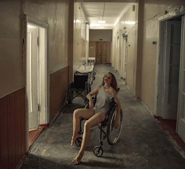 Geslagen vrouw slachtoffer van geweld zit in een rolstoel in een ziekenhuis. - Foto, afbeelding