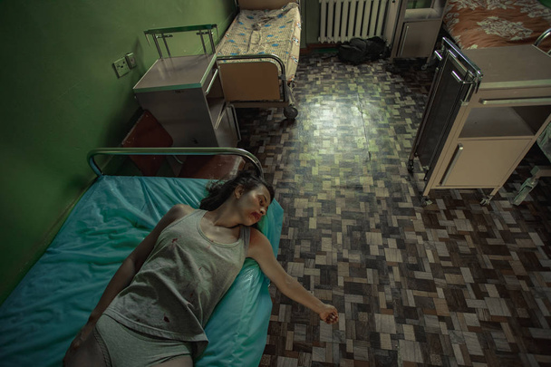 Побита жінка жертва насильства лежить на ліжку в лікарняній палаті
. - Фото, зображення