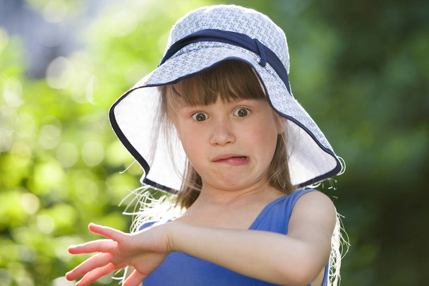 Κοντινό πορτρέτο ενός σοβαρού κοριτσιού με ένα μεγάλο καπέλο. Τέκνο - Φωτογραφία, εικόνα