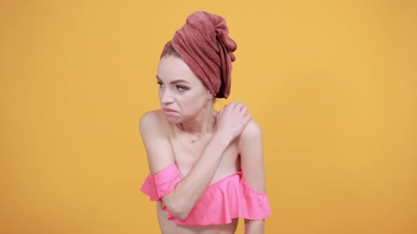 νεαρό κορίτσι με πετσέτα στο κεφάλι της πάνω από απομονωμένο πορτοκαλί φόντο δείχνει τα συναισθήματα - Πλάνα, βίντεο