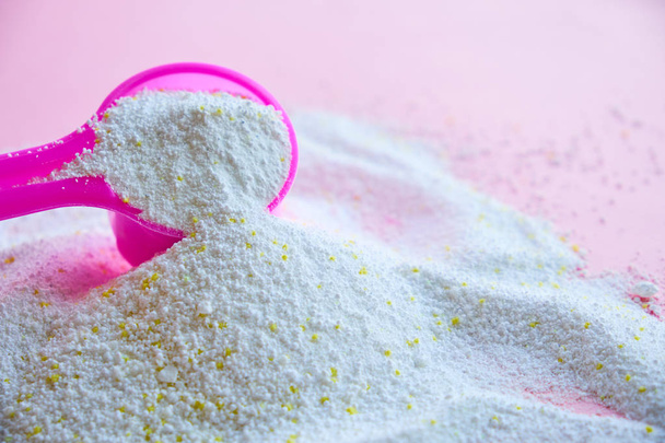 Μεζούρα με σκόνη πλυντηρίου σε ροζ φόντο - Φωτογραφία, εικόνα