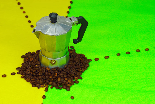 kleine traditionelle italienische Kaffeekanne auf grünem und gelbem Hintergrund. Kaffeebohnen. - Foto, Bild