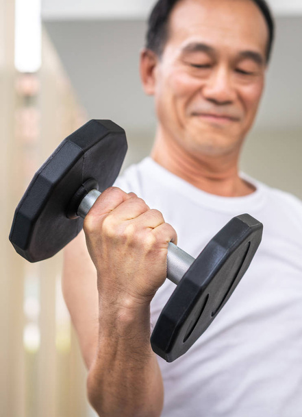 Senior man Lifting halter in fitness gym. - Foto, afbeelding