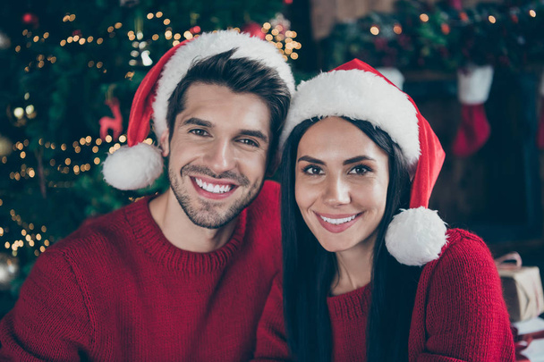 Close up photo of two romantic married people enjoying christmas celebrate x-mas holidays wearing newyear hat in house with noel decoration newyear lights indoors - Fotoğraf, Görsel