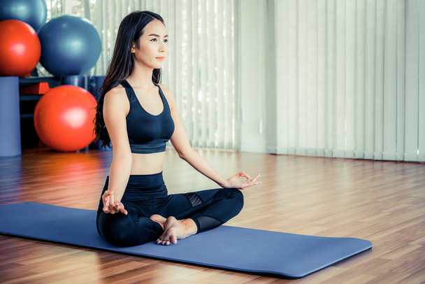 Jonge vrouw beoefenen yoga in een gym Studio. - Foto, afbeelding