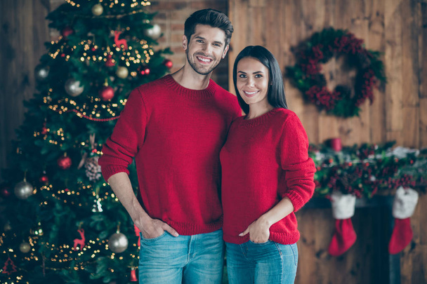 Portrait of two romantic people man and girl enjoy christmas vacation x-mas holidays standing near fir evergreen tree noel decoration in house indoors - Fotó, kép