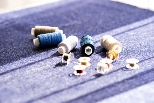 Sewing threads on a blue background. Cut and sew. Needlework concept. Soft meter, spools of thread for creative people. - Foto, Bild
