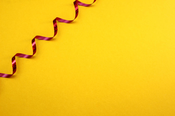 yellow canvas background with red twisting ribbon - Zdjęcie, obraz