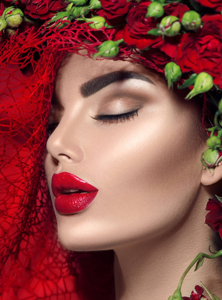Beauty model girl with red roses flower wreath and fashion makeup. Flowers hairstyle - Foto, imagen