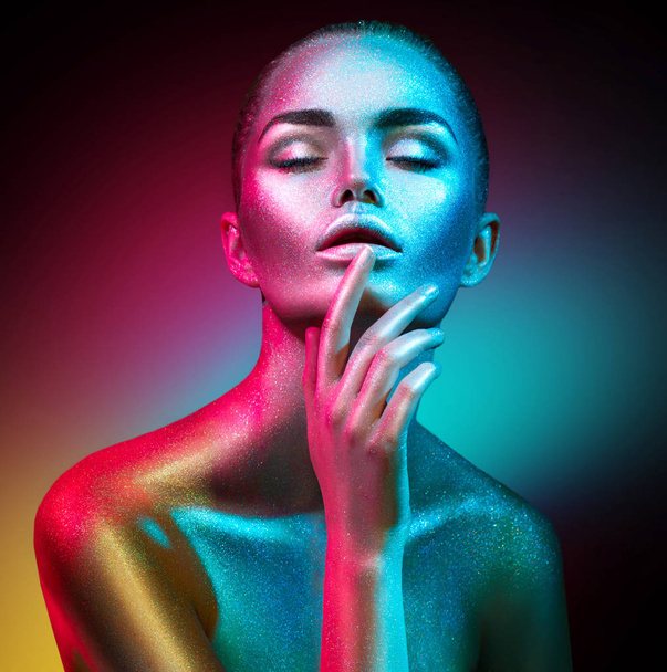 Fashion model woman in colorful bright sparkles and neon lights posing in studio. Art design colorful vivid makeup. - Zdjęcie, obraz