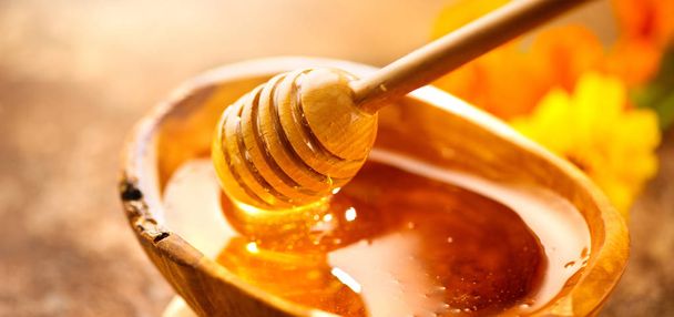 蜂蜜。ハチミツのディップから垂れ下がる健康的な有機濃い蜂蜜 - 写真・画像