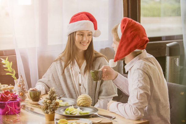 guy and girl celebrate Christmas in a cafe - Zdjęcie, obraz