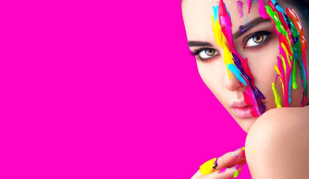 Female model with colorful paints on face. Portrait of woman with flowing liquid paint. - Photo, image