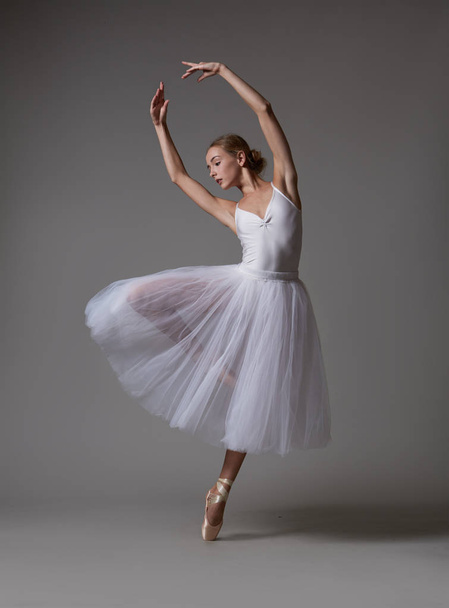 Bailarina em vestido branco e sapatos pontiagudos dançando
 - Foto, Imagem