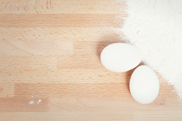 белые яйца рядом с мукой
 - Фото, изображение