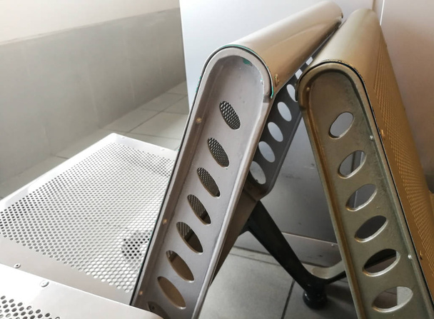 Niewygodna metalowa ławka / krzesło w poczekalni lotniska. - Zdjęcie, obraz