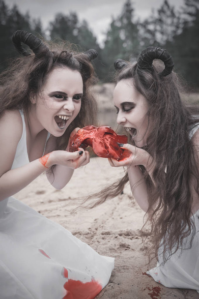 Два жахливі демони їдять сире м'ясо
  - Фото, зображення
