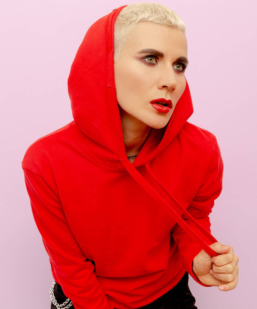 Girl in a red sweatshirt with short hair. Street fashion style - 写真・画像