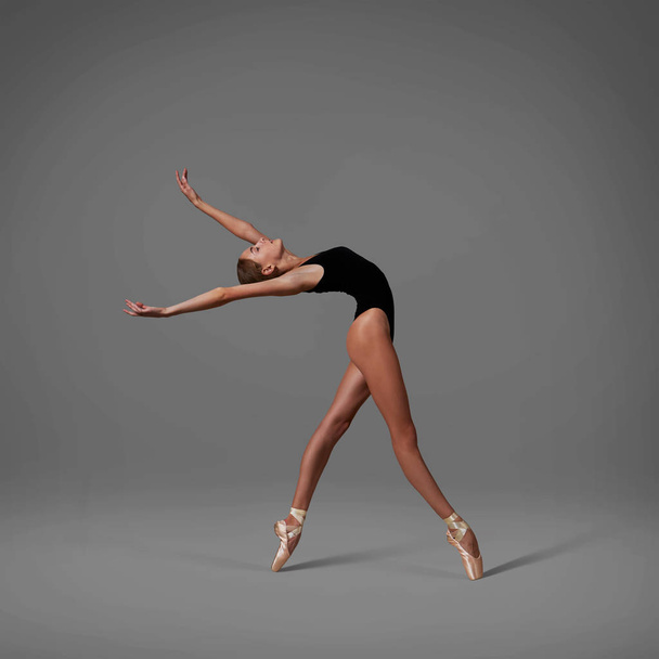 Ballerina im schwarzen Trikot und Spitzenschuhen tanzen - Foto, Bild