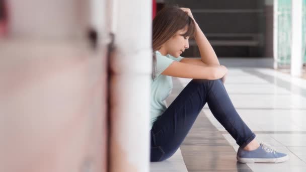 πλάνα από το θύμα εκφοβισμού κορίτσι που κάθεται στο πάτωμα του διαδρόμου στο γυμνάσιο - Πλάνα, βίντεο