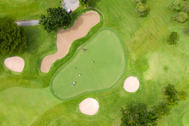 Letecký pohled na hráče na zeleném golfovém hřišti. Golfer hraje na - Fotografie, Obrázek