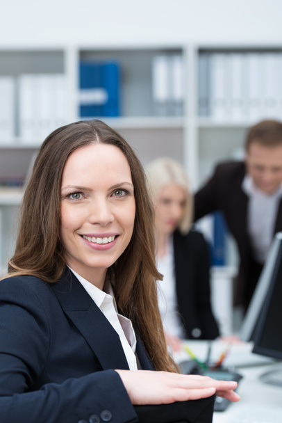 Smiling businesswoman in a busy office - Photo, Image