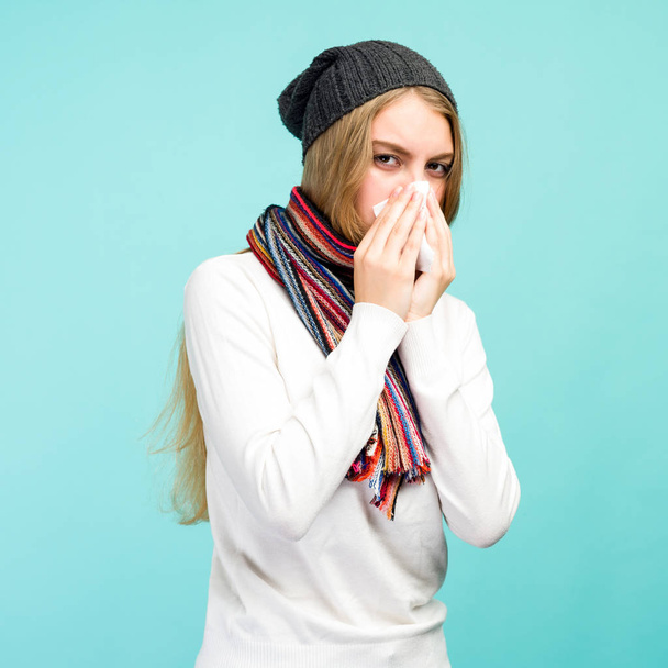 Conceito de saúde e medicina - Menina adolescente triste soprando nariz no tecido, em um fundo azul. Menina bonita fria com ranho
. - Foto, Imagem