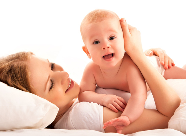 happy family. Mother and baby lie and embrace in the bed - Photo, image