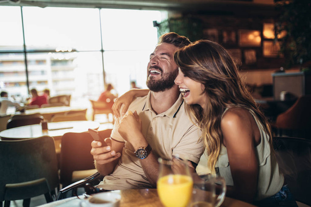 Couple heureux avec smartphone boire du thé ou du café au café. Sel
 - Photo, image