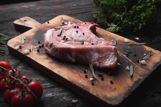 raw steak on the table, fresh meat lies on a cutting board, - Foto, imagen