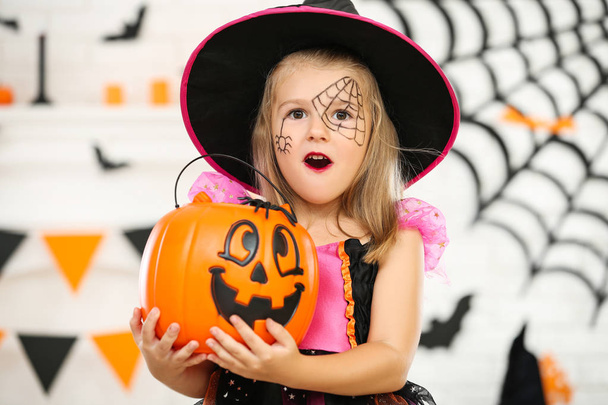 Young girl in halloween costume holding pumpkin bucket - Foto, Bild