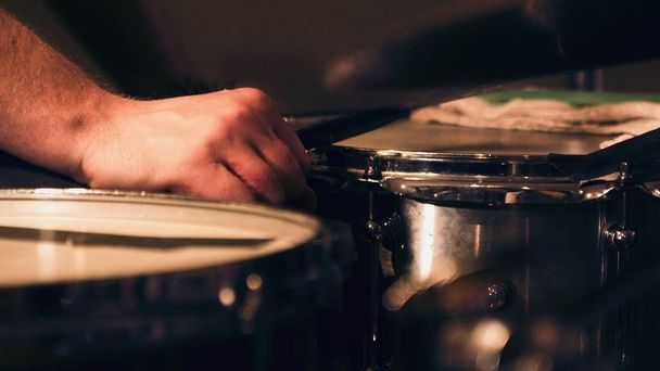 Closeup shot of drums with a hand holding the drum stick - Valokuva, kuva