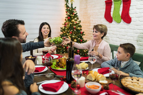 Família feliz desfrutando de jantar de Natal juntos na mesa de jantar em casa
 - Foto, Imagem